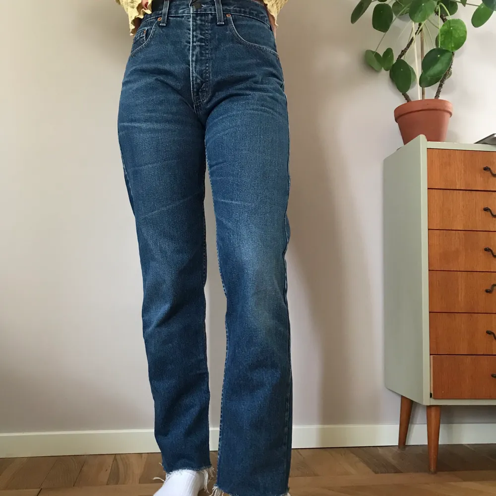 Supersnygga Levi’s jeans i mörkblå tvätt med rak passform. Står storlek 30/34 men de är betydligt mindre än det. De passar någon som har 26/27 i storlek i midjan och på längden är de avklippta men kan klippas ännu kortare om man vill det!. Jeans & Byxor.