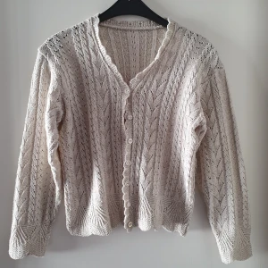 Vintage stickad kofta - Vintage gräddvit, beige stickad kofta.Några få lite lösare trådar kan finnas. Står ej storlek men uppskattar till ca storlek S. Fraktkostnad blir 69kr.