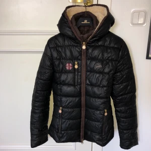 Jacka - Höst/vinterjacka. Varm men andas bra. Två dragkedjor till en ”innerjacka”. Mysigt fluff i luvan. Bröstficka samt fickor fram med dragkedja. Strl. XS men sitter lika bra på S. Superfint skick. 