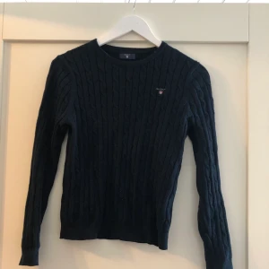 Marinblå kabelstickad gant - En superfin knappt använd marinblå kabelstickad gant-tröja. Storlek 170 (XS). Bra pris vid snabb affär! 