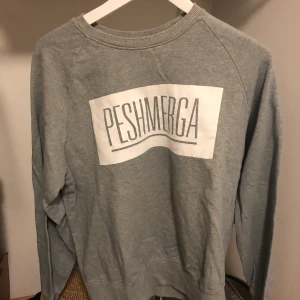 Tröja med tryck - Tröja med ”Peshmerga” skriven på. Fick som gåva. Använd fåtal gånger. Storlek syns på bild. Unisex 