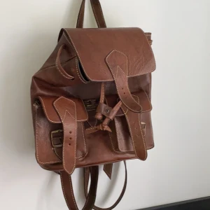 Läder ryggsäck  - Köpt i Spanien, fint skick.  Får plats med 11 tums dator. 