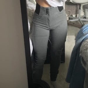 High waisted gråa byxor - Stretchiga och supersköna att ha på sig (formar sig väldigt bra utefter kroppen), nästan aldrig använda, i bra skick, detaljer - mörka silverknappar och ribbade i midjan, inte jeans-material, lite långa på mig som är 151, pris kan diskuteras - frakt ingår