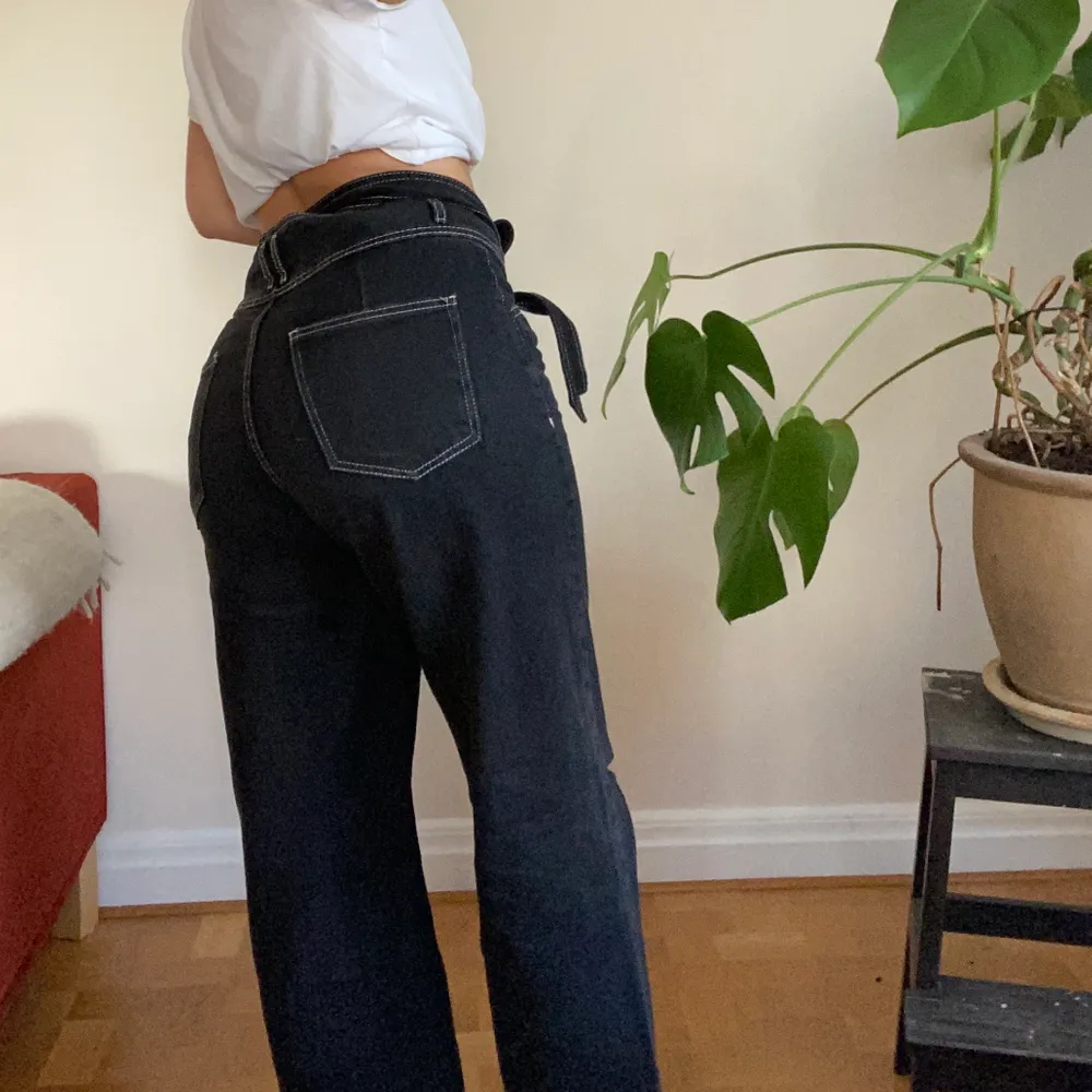 Fina svarta jeans med vita sömmar och tillhörande skärp!🖤 Jag är 1.60!. Jeans & Byxor.