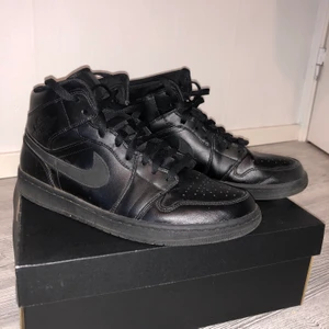 Black Jordan 1 Mid - Knappt sliten svart Jordan 1 Mid med lätt synliga veck (framsula) Skick 9/10 Box ingår. Köparen tar hand om fraktavgifter