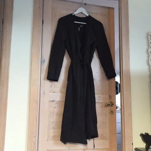  - Svart kappa/trench som sträcker sig nästan till anklarna. Tunt vårmaterial med ett smalt midjeskärp. Sparsamt använd i superskönt material. Från H&M. 