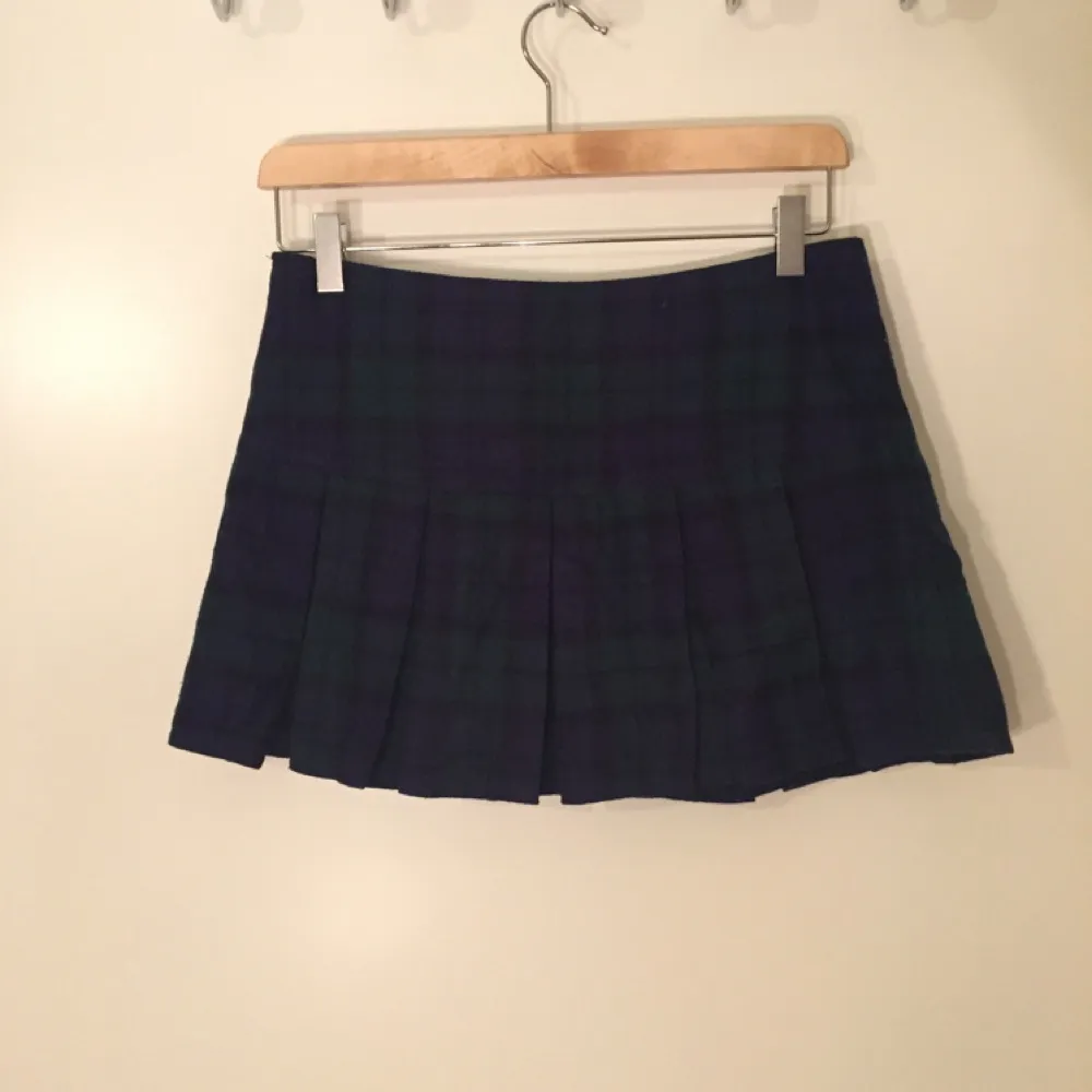 Plisserad skotskrutig kjol köpt i Korea. Tyget är som flanell och är mörkgrönt/marint. Låg midja och väldigt kort.. Kjolar.