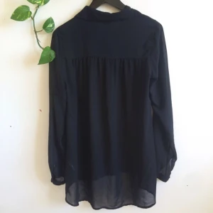  - Lång tunn skjorta i genomskinligt material.