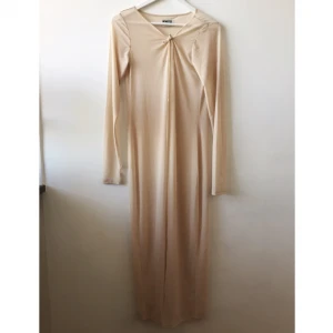  - Transparent nude klänning som jag klippt isär hela vägen från nedre till övre kant för att plagget gjorde sig bättre som en slags kaftan med smala ärmar. Går fint att bära knuten eller helt öppen. Går till vaderna på mig som är 164cm. Hål för tFrån weekday.