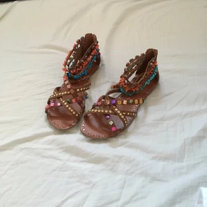  - Sandaletter från Scorett, nypris 500 kr. Saknar pärlor på ena bandet på vänstra sandalen (bild 3). Man skulle eventuellt kunna ta bort resten av pärlorna också så att det inte ser trasigt ut. Använda 1-2 gånger! 