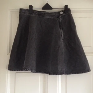  - "Washed out"-svart jeans kjol med snygg knapp i sidan