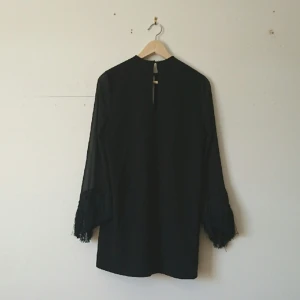  - En klänning för dom av oss bohemer som vill ha det lite bohemiskt och lite classy på en o samma gång! Härliga ärmar med fransar och brokering längst ner, nyckelhål båda fram och bak. 