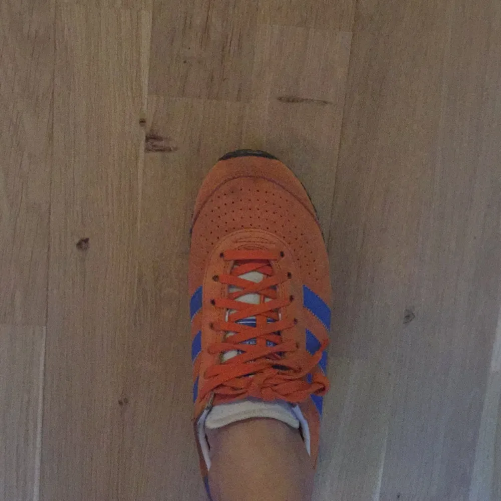 Färglada adidas sneakers med ljusgul sula, orange mocka och blå ränder. Skor.