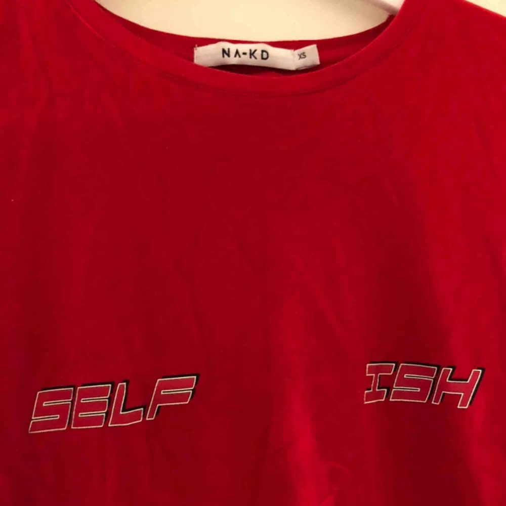 Röd T-shirt från NA-KD med tryck i storlek XS. Köparen står för frakt på ca 50kr😜. T-shirts.