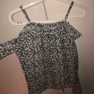  - Jättefin tröja från bikbok. Med svartvitt blommönster. Suuuperskönt tunt material. Det går som en resår som ska sitta nedanför axlarna och sedan tunnare band som håller upp tröjan på axlarna. Resår även nertill i midjan.