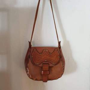 Brun vintage väska i läder 🍂  Mått:  Längd: 21 cm Bredd: 28 cm Djup: 8 cm Axelrem: 93 cm   150:- plus frakt 63:- spårbart.
