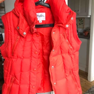  - Röd väst från Björn Borg. Har luva och dubbla fickor. 