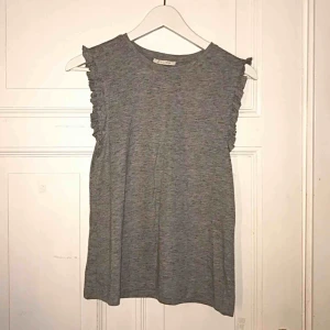 - Armlös t-shirt med volanger från VERO MODA. Fint skick, knappt använd.   Frakt ingår! ☀️🍀🍃 