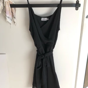 Svart klänning från Iva Nikolina X NA-KD - Säljer den svarta klänningen från Iva Nikolina X NA-KD, den andra bilden visar hur klänningen sitter på modellen men den är i svart som jag säljer och i storlek 34. Har aldrig använt den så den är i ny skick den har hängt i garderoben något år bara.         Inte mina bilder!!