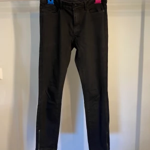 Svarta jeans - Snygga svarta jeans med dragkedja vid foten! Knappt använda!