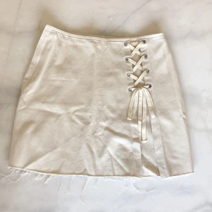 Jeanskjol med snörning  - Helt oanvänd benvit jenanskjol med snörning framtill från Weekday. Dragkedja i sidan. Nypris 400kr, lapparna kvar. Strl 40 & jag har vanligtvis strl M✨ Frakten är spårbar och inräknad i priset! 