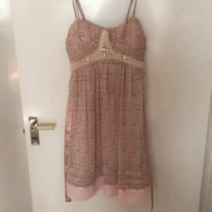 Rosa bandlös klänning - Rosa bandlös klänning med band runt midjan, Köpt för tre årsen men använd två gånger. Köpt feån Scala