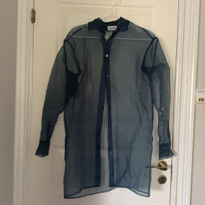 Genomskinlig skjorta - Blå genomskinlig lite längre skjorta i ett material jag har svårt att förklara. Obersized. Köpt från Weekday i vintras inför en temafest som förutom då aldrig kommit till användning. Därav som ny. Frakt tillkommer eller så kan jag mötas upp i Stockholm. 