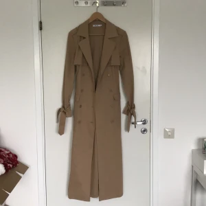Beige kappa från NA-KD - Säljer min fina fina kappa från NA-KD. Det är storlek 34 men passar både small och medium. Den är använd 2 gånger, säljer den eftersom jag inte använder den längre. Nypris är 1000kr, den är precis som ny och är så unik med många fina detaljer. Bara att skriva om ni har frågor! Ps. Den framhäver kurvorna väldigt snyggt😍