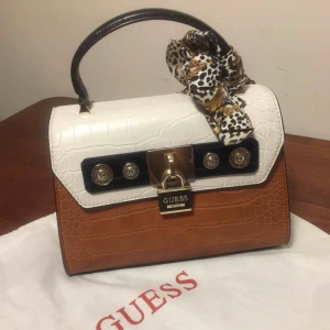  - Äkta Guess handväska ☺️köpte föra året, men använd sparsamt . Ny pris 1499 mitt pris nu 700😊 Fin handväska och i lagom bra storlek  . Dust bag med följer 😛 frakt 104 kr . Pris kan diskutera vid snabb affär . 