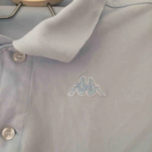  - Ljusblå piké från kappa. Frakt 36kr