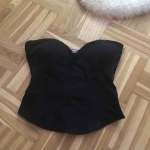  - Svart ärmlös topp med dragkedja på en sidan. Stl L men passar ett M också. 