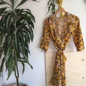  - Superfin gul blommig omlottklänning med knyt från Monki, fint skick. Slutsåld förra sommaren. 