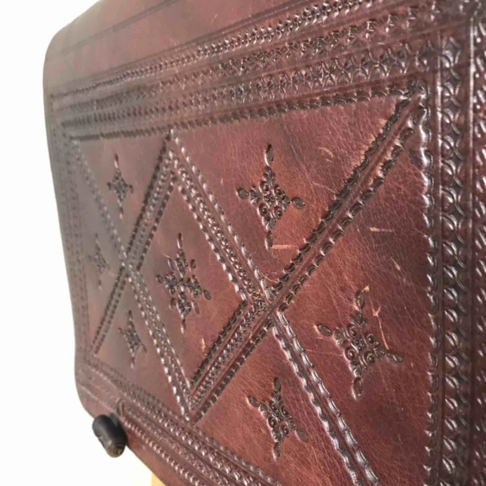 Vacker läderväska inköpt i Essaouira i Marocko. Äkta läder, enkel i sin utformning med två separata fack inuti och tillknäppning i form av små läderknutar på utsidan av locket. Präglat läder och justerbar längd på axelremmen. . Väskor.