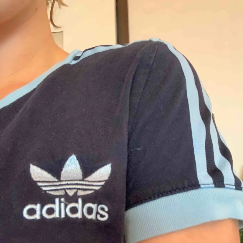 Mörkblå adidas original t-shirt med ljusblå stripes. Storlek 38 men passar även en s. T-shirts.