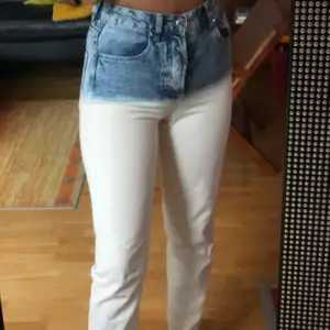 Ett par vita mom jeans som fadear ut till blått upptill. De är i storlek 36 och helt oanvända, därav säljs de. Om du inte vill betala frakten kan vi mötas upp i centrala Stockholm ❤️