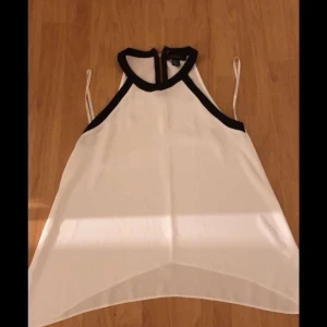 En vit blus med svart detalj - En vit blus med svart detalj vid halsen använd några gånger strl 36