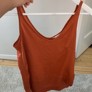 Orange/kopparfärgad blus - Jättefin blus från H&M som är i mycket bra skick. Ändast använd 2 gånger! Är i storlek 34 men passar 36or lika bra