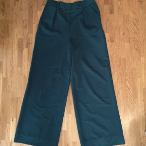 Raka kostumbyxor med hög midja - Mörkgröna raka kostumbyxor med snygg passform i midja. Nyskick. Köparen betalar frakten.