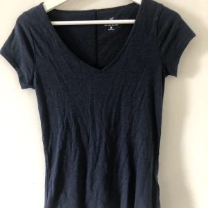 Hollister T-hirt strl XS - Mörkblå V-ringad T-shirt från Hollister i strl XS. Sparsamt använd och i fint skick, 50 kr + frakt🤍