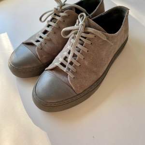 Hej! Jag säljer ett par axel arigato skor i färgen grå. Riktigt snygga och i bra skick. Finns en liten skråma på ena skon (se bild) annars jättefina och fräscha. 