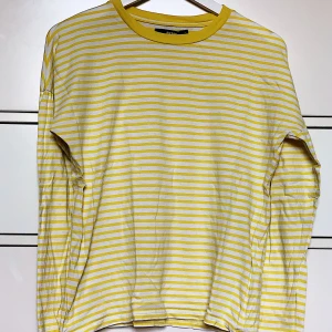 Randig långärmad  - Basic gul/vit randig långärmad tröja. Perfekt om man söker en tröja att ha under ex. väst eller annat. Bra skick. Lite större passform men skulle säga att det är en M/L. Pris kan diskuteras & frakt står köparen för. Möts gärna upp annars! 