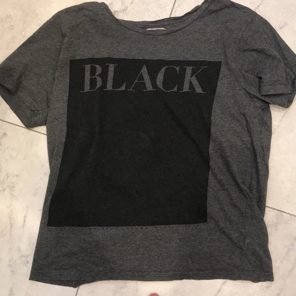 Weekday t-shirt där det står Black på. Ovanför Black så har den två små hål som inte syns när du har på dig den😊Frakt 50kr😊. T-shirts.