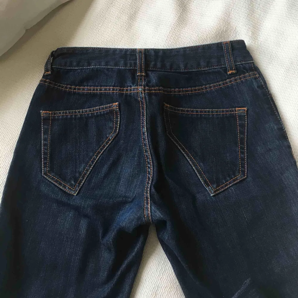 Ett par mörkablåa jeans. De är inte bootcut men de är inte helt lösa längst smalbenen. De är ganska långa, själv behöver jag vika upp dem. De går ungefär till ovanför naveln.. Jeans & Byxor.