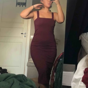  - Vinröd klänning, slutar under knäna. Stretchigt material Frakt ingår 