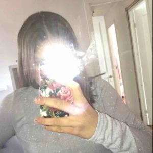  - En glittrig grå/ljusblå tröja. Den har en utsvängning längst ner. Inte använd så mycket. Fint skick. Köpare står för frakt. 