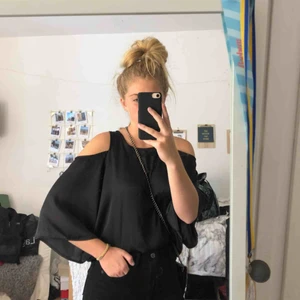  - En silkesblus i svart med öppna axlar och utsvängda ärmar😊 Aldrig använd med prislapp kvar, köpt för 249kr💓
