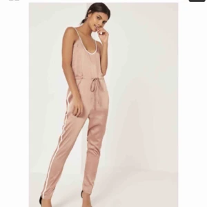  - Satin nelly jumpsuit. Skit snygg jumpsuit. Säljes pågrund av köpte två st olika strl därför är denna aldrig använd NOTERA taggen är kvar. Observera även färgskillnaden på bilderna som är lånade. Mörkare IRL.
