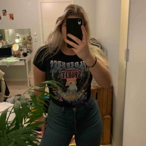  - En svart t-shirt med coolt tryck. 