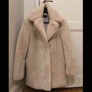  - Superfin vit eller krämvit faux fur i mjuk fuskpäls från Topshop. Varm & Skön! Fint skick, storlek 34. Knäpps med 3 dolda knappar. Kan skicka mot fraktkostnad eller mötas upp i Stockholm! ✨☃️✨