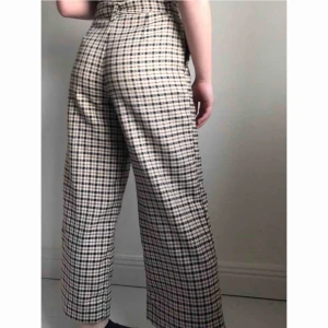  - Vida byxor i skönt material som passar lika bra till både fest som vardag. Snyggt mönster och midjan blir justerbar med ”bältet”. Modellen är 160cm lång